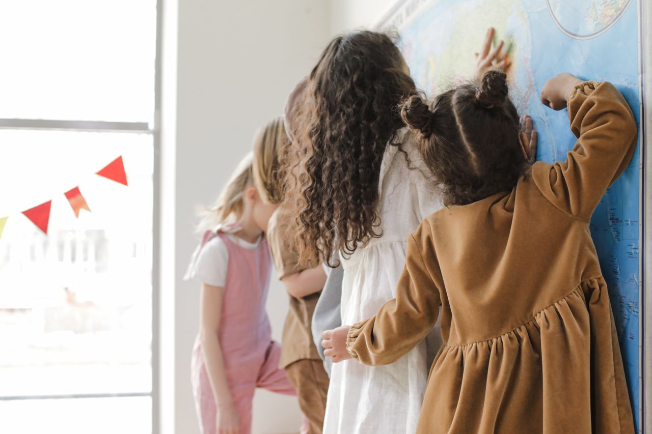 Young children learning geography with a map in a classroom setting.